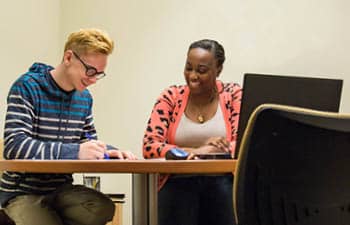 An FLCC student and admissions counselor completing college paperwork together.