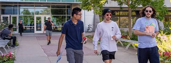 A group of three students walking outside FLCC main campus in Canandaigua, NY.