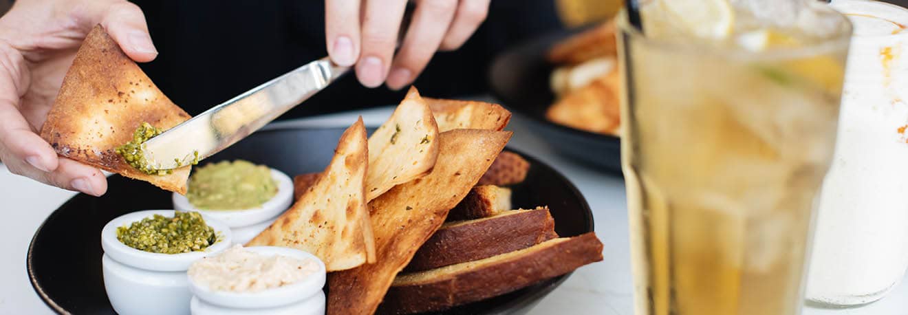 Fresh chips and toasted bread served with three homemade dips.