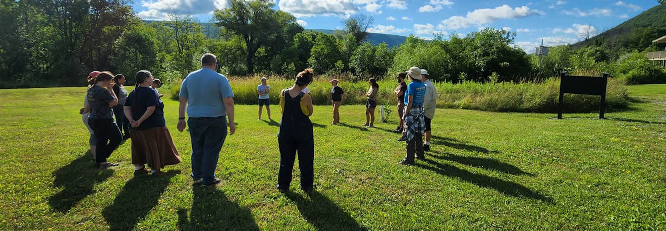 A group of community members standing in a circle at Muller Field Station.